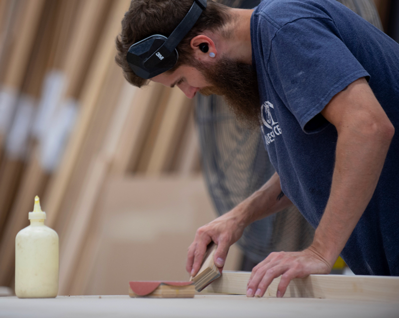 Kundig craftsman sanding custom commercial cabinetry